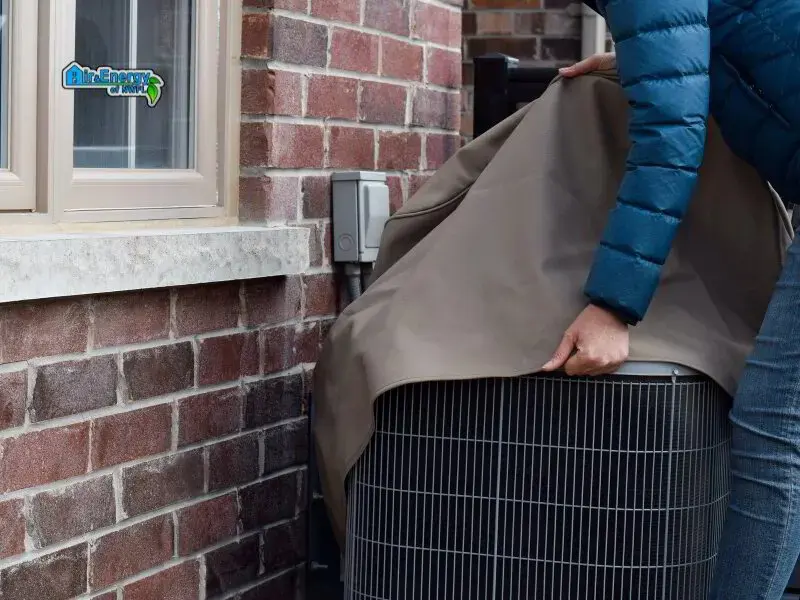 homeowner covering AC outdoor unit