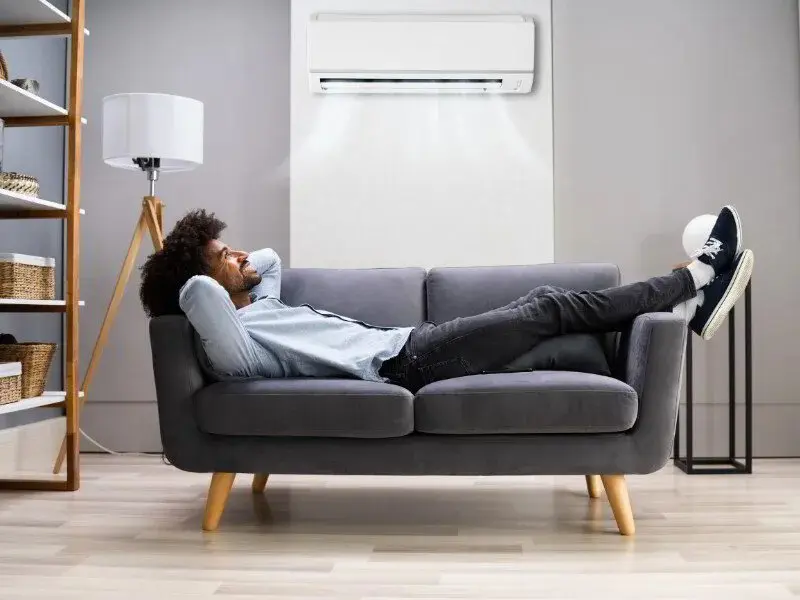 a man enjoying the AC inside his living room